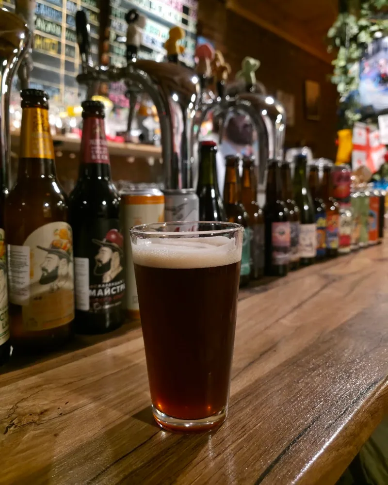 Glass of amber craft beer on a wooden bar at Sma