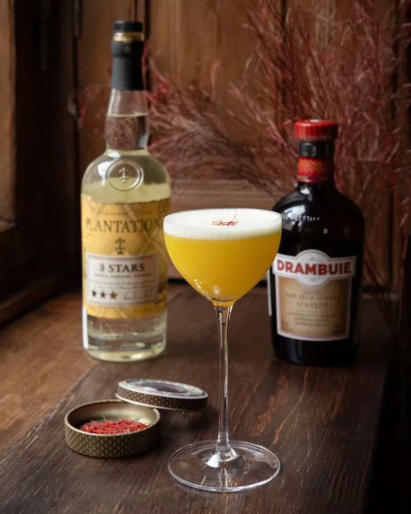 Yellow cocktail garnished with saffron in a stemmed glass at Snobs
