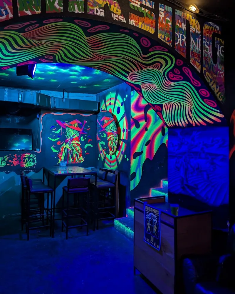 Bar seating area with psychedelic uv light murals at Sonder Bar