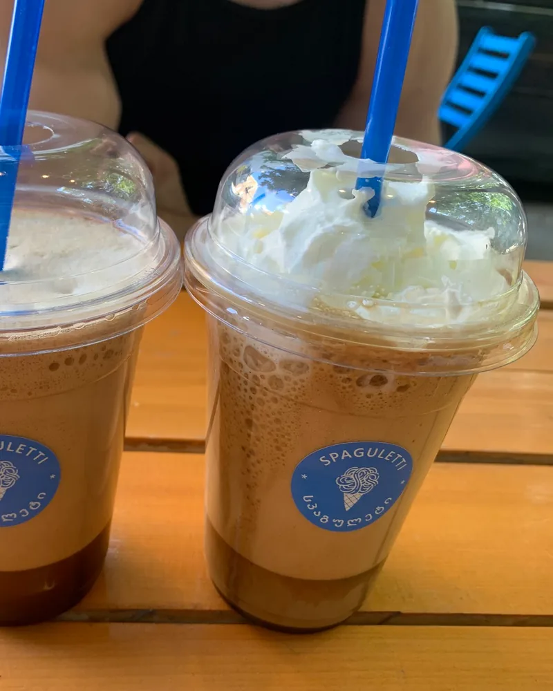 Two iced blended coffee drinks in plastic cups with blue straws at Spaguletti Ice Cream & Waffles