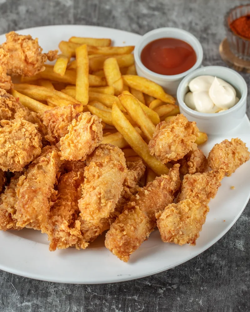 Fried chicken tenders with french fries and dips at Spectra