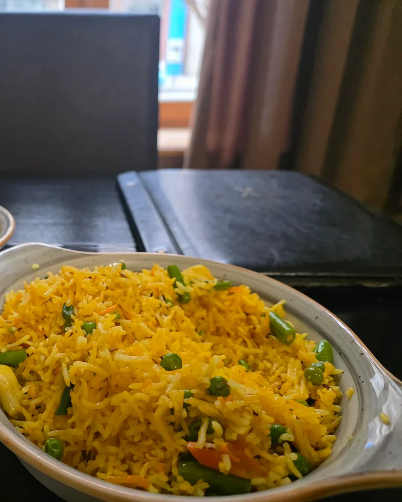 Vegetable biryani with peas, green beans and carrot in an oval dish at Spice Garden