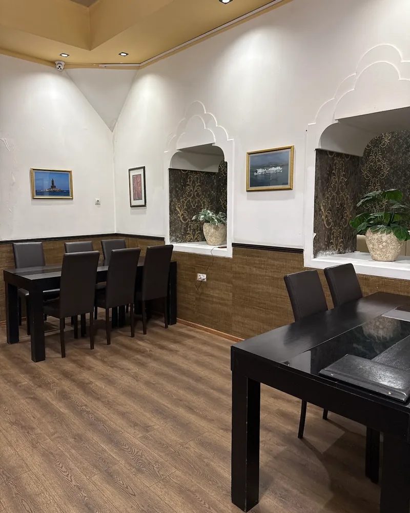 Dining area with tables and arched wall cutouts at Spice Garden