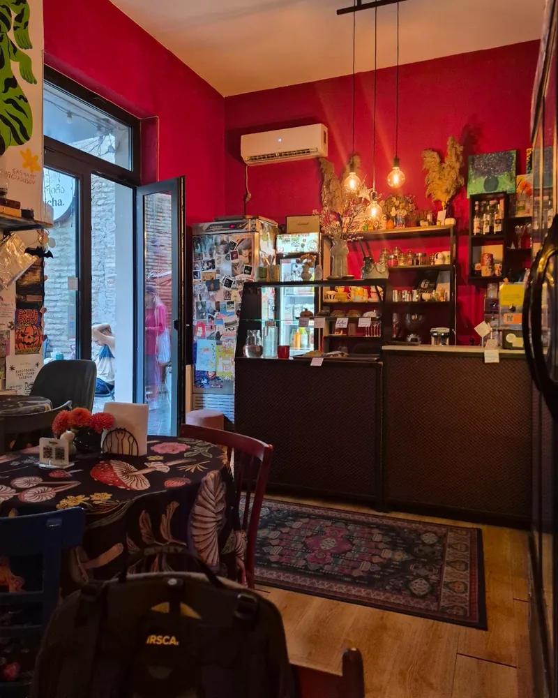 Cafe room with red walls, a counter and a glass display case at Stricha