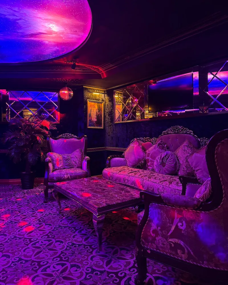 Karaoke lounge with ornate seating and neon lighting at Studio8 Karaoke