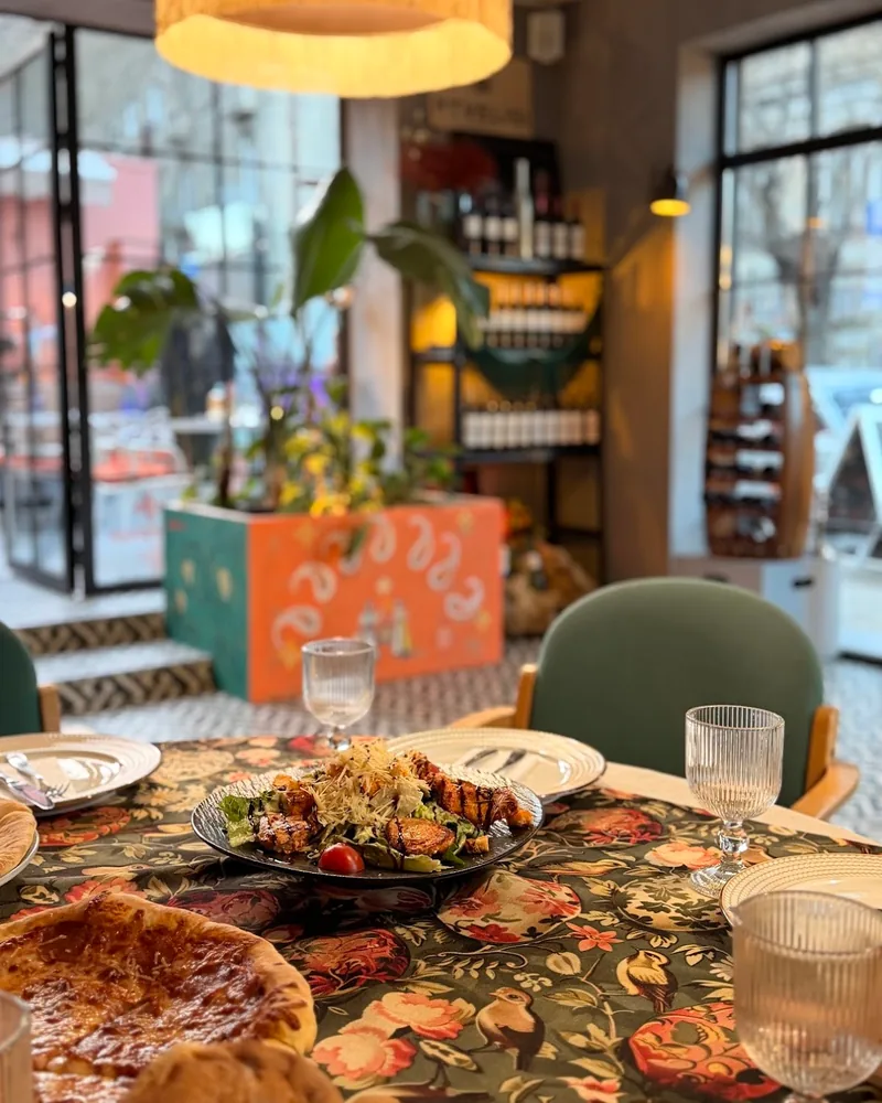 Salad with grilled chicken and bread on a floral tablecloth at Supra Sololakshi