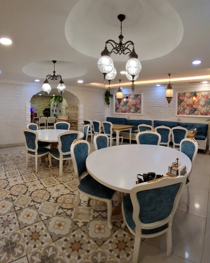 Dining room with blue chairs and patterned floor tiles at Supra Turkish