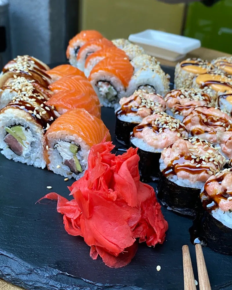 Sushi roll platter on a slate board with pickled ginger at Sushi Rolls