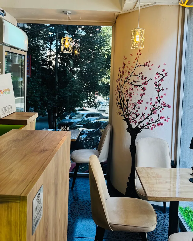 Dining area with cherry blossom wall painting at Sushi Rolls