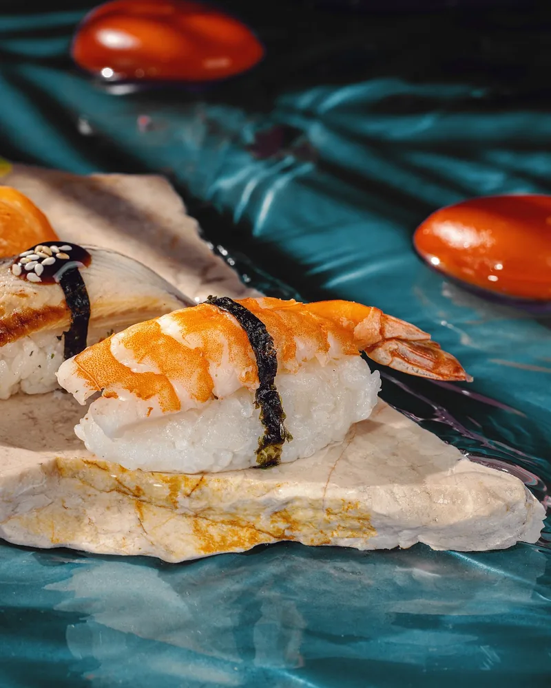 Assorted nigiri sushi on a stone slab at Sushi Way