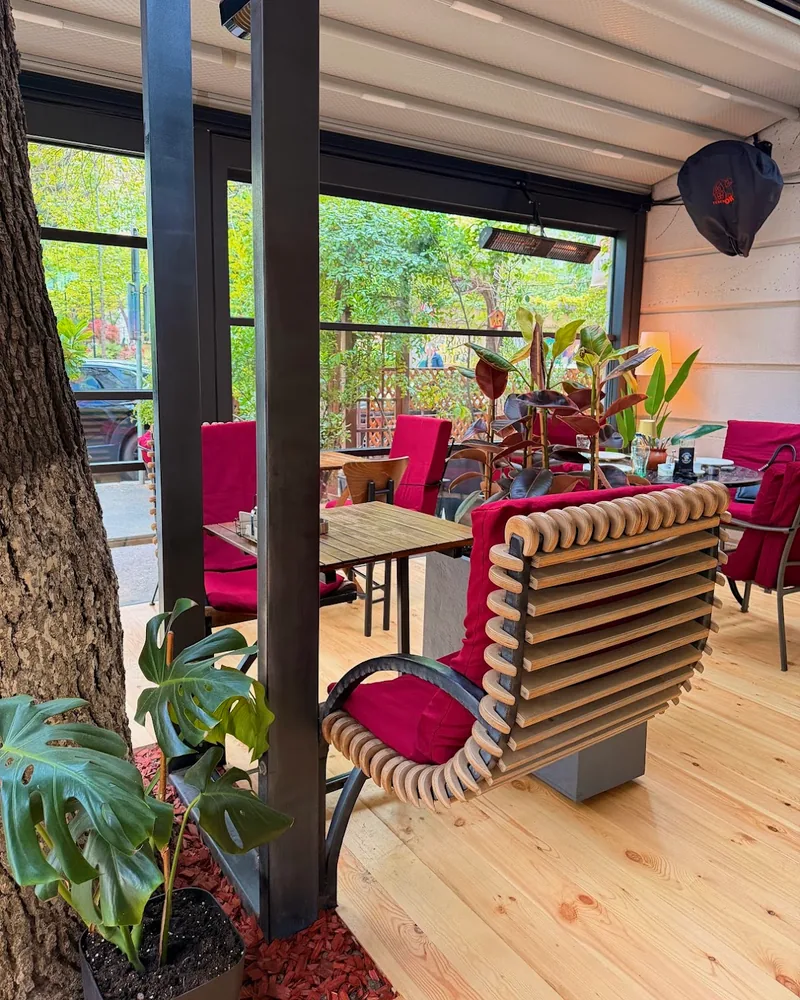 Covered terrace seating with wooden benches and red cushions at Sushi Way