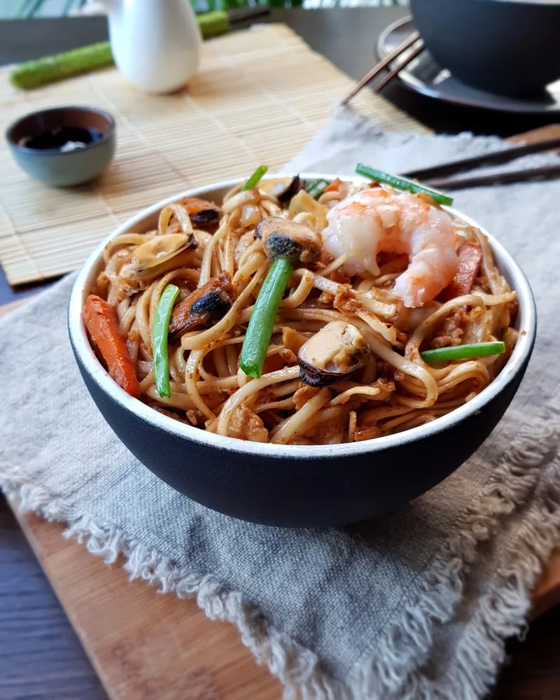Seafood noodles with shrimp and mussels in a bowl at SushiCo
