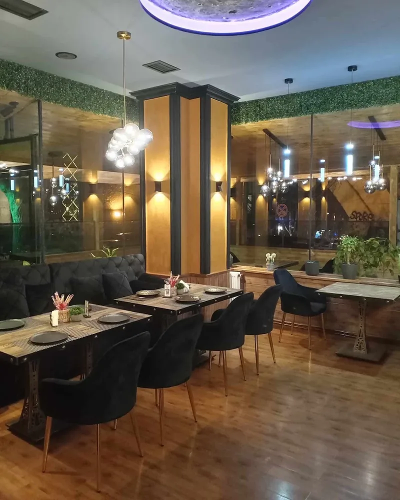 Dining area with black velvet chairs and ceiling light feature at SushiCo
