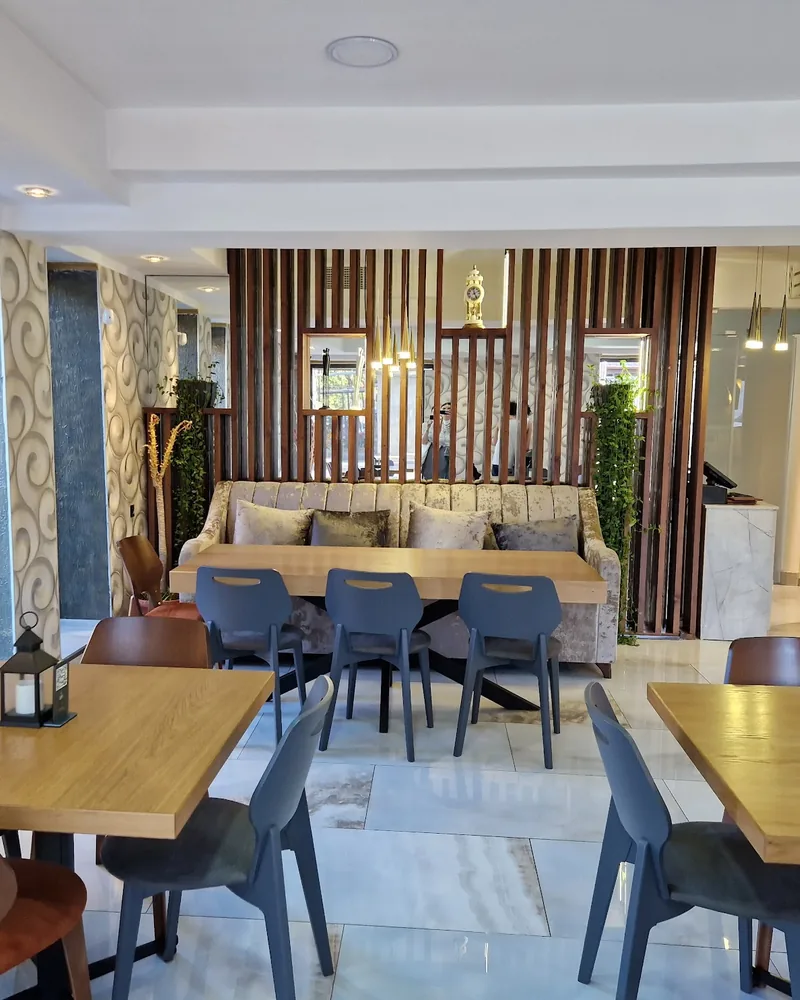 Dining room with wooden tables and slat wood divider at Taste of India