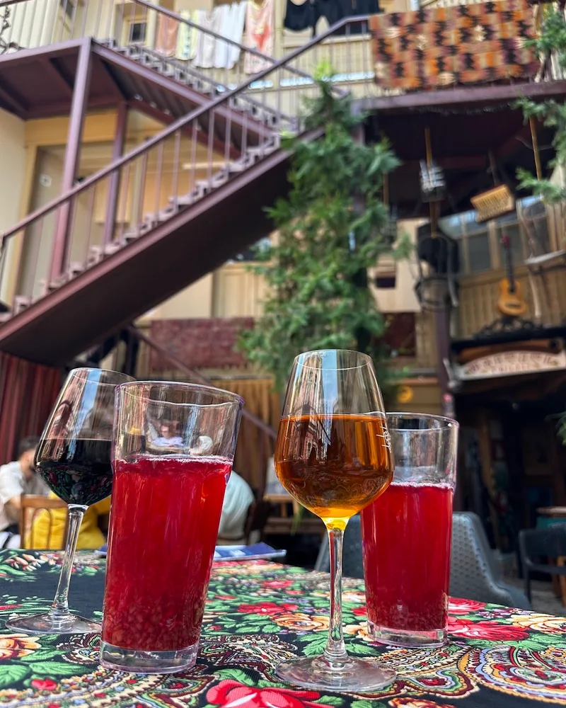 Wine and red juice drinks on a floral tablecloth at Tbileli