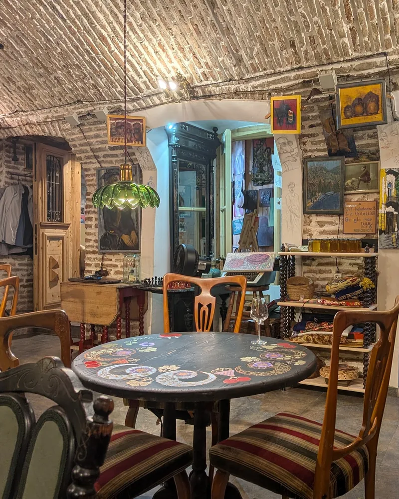 Brick-vaulted cellar seating area with painted table at Tbileli