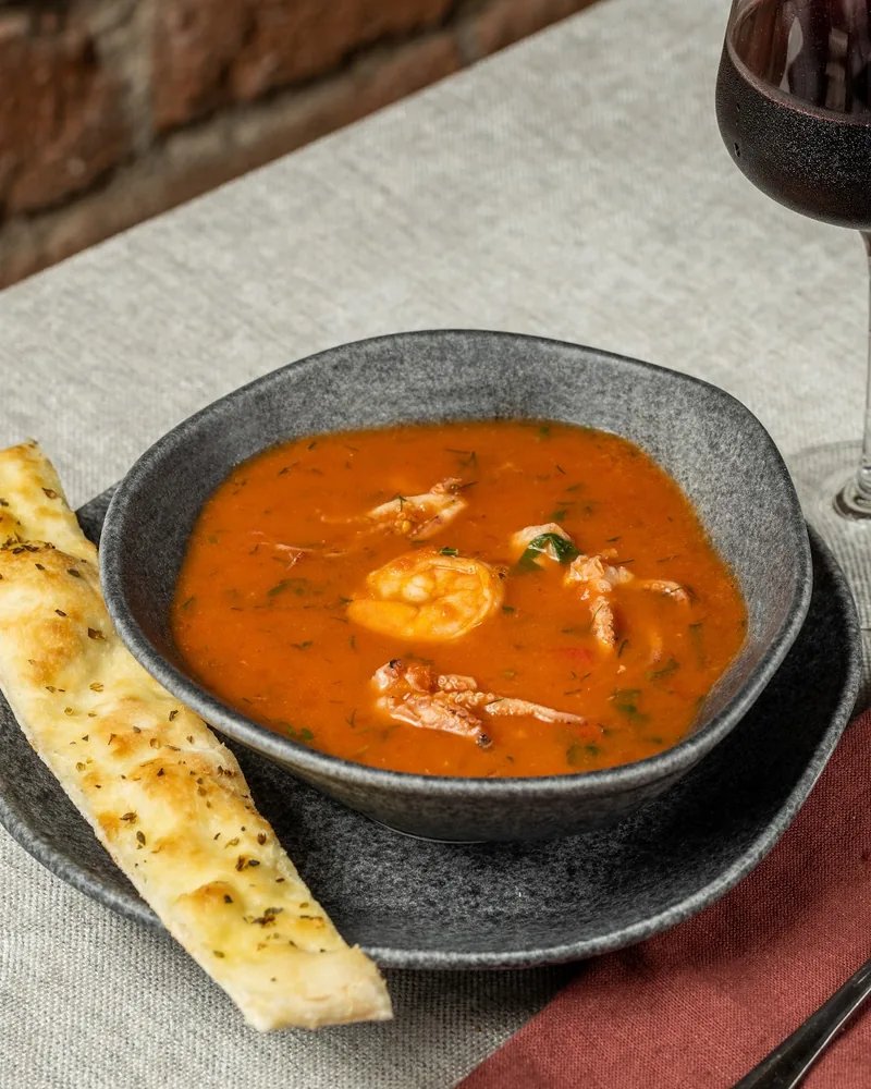Seafood tomato soup with breadstick and wine at Tbilisimo