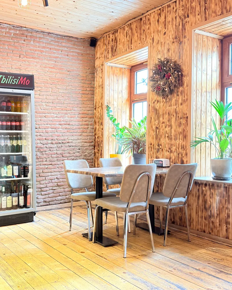 Dining area with wood paneled walls and brick at Tbilisimo