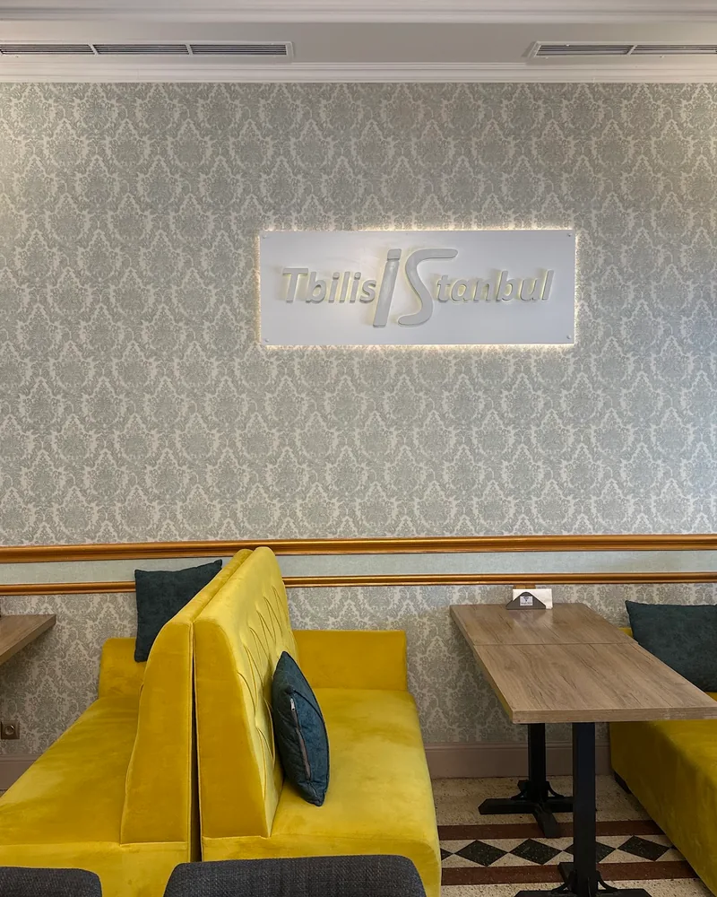 Dining area with yellow velvet booths and damask wallpaper at TbilisIstanbul