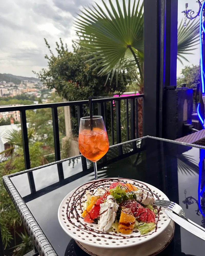Spritz and citrus salad on a terrace table overlooking the city at Terrace Bar