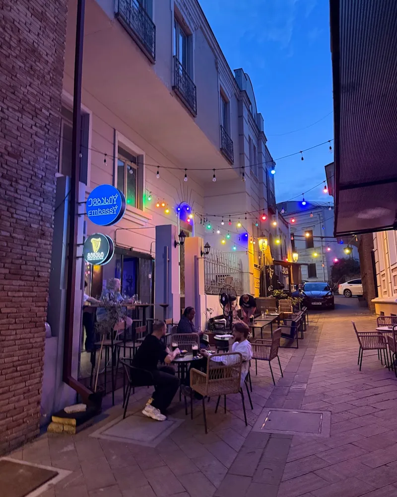 Outdoor street seating area with festoon lights at The Embassy Bar
