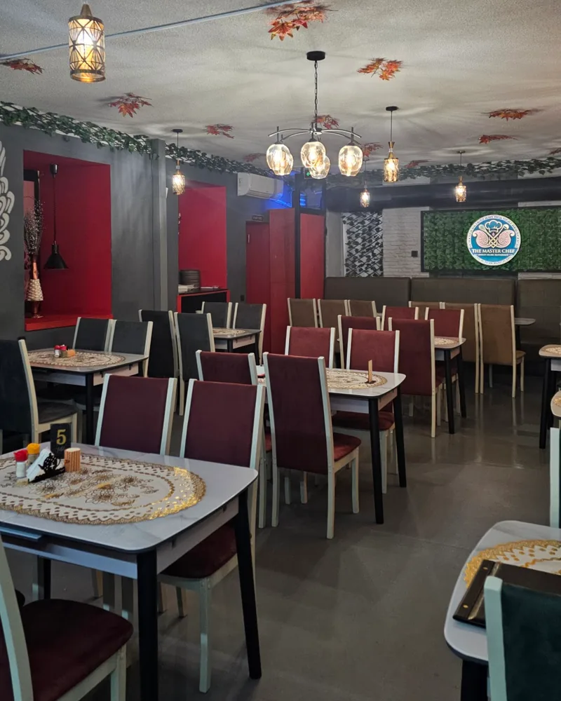 Dining room with tables and leaf decorations on the ceiling at The Master Chef