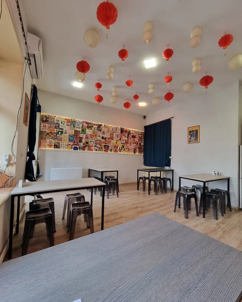 Dining room with paper lanterns and a collage wall at The Noodle House