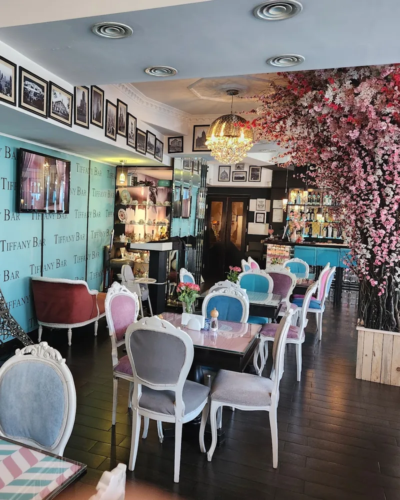 Indoor dining room with pastel chairs and an artificial blossom tree at Tiffany Bar & Terrace