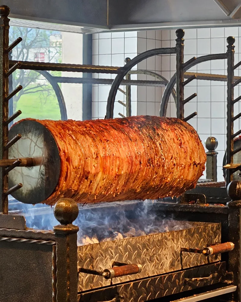 Horizontal rotisserie shawarma over hot coals at Tiflis Fast Food