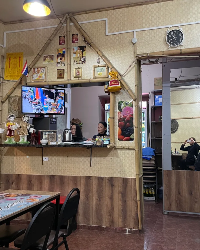 Casual dining area with bamboo decor and service counter at Tom Yum