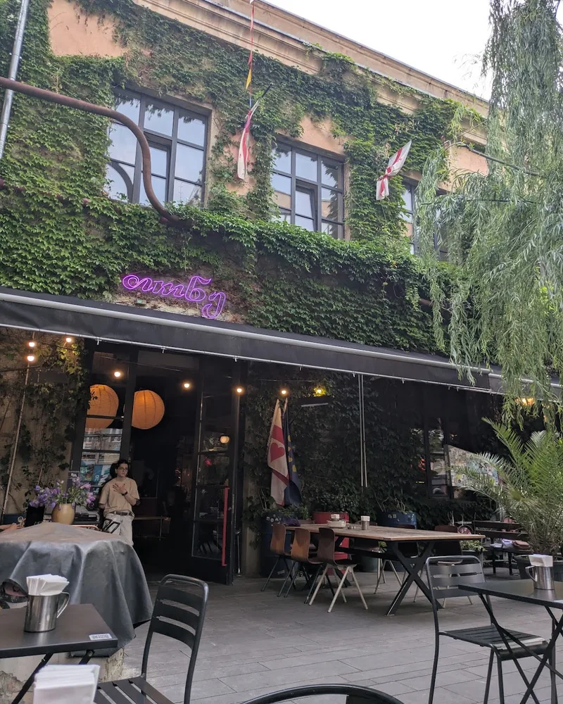 Outdoor patio tables under an ivy-covered facade at Tone