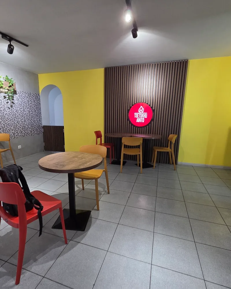 Dining area with simple tables and yellow accent wall at Tsetskhli Ainto