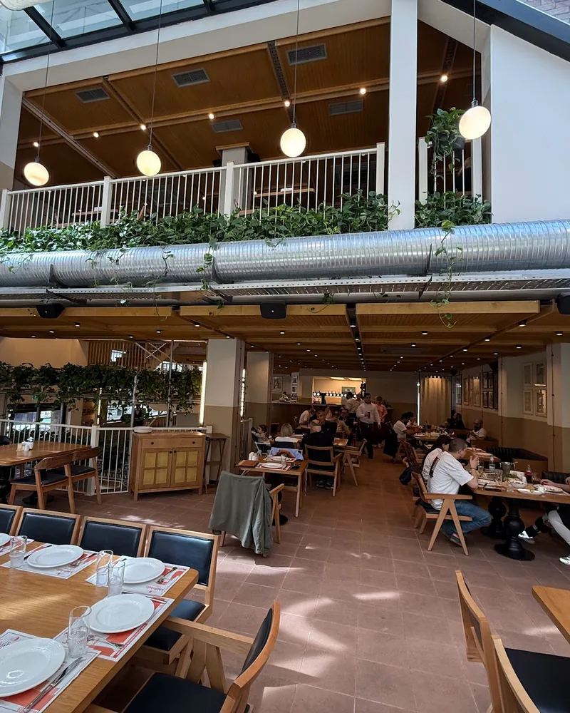 Two-level dining hall with skylight and mezzanine at Tsiskvili Beer Square in Saburtalo