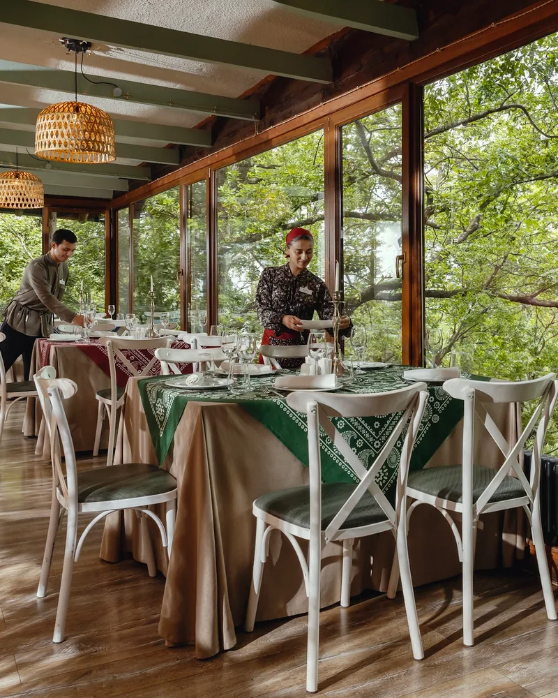 Enclosed veranda dining area overlooking forest at Tsiskvili (Tskneti)