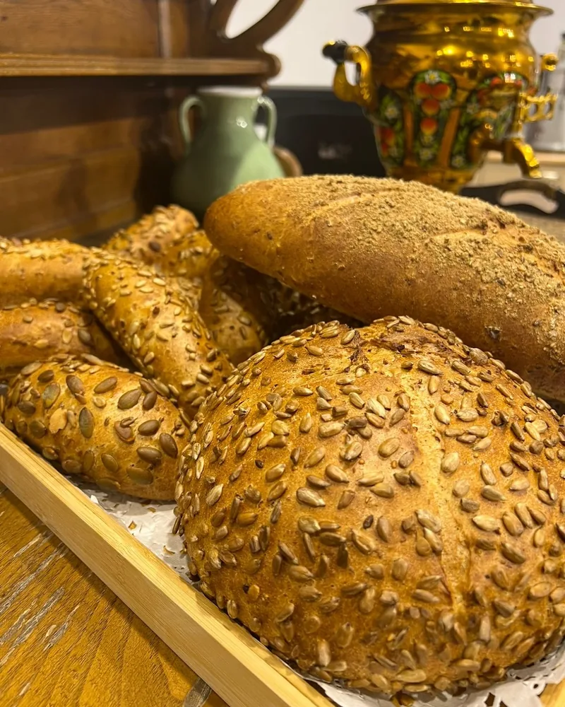 Seeded bread loaves and rolls on a tray at Ars Gusto Culinary Academy