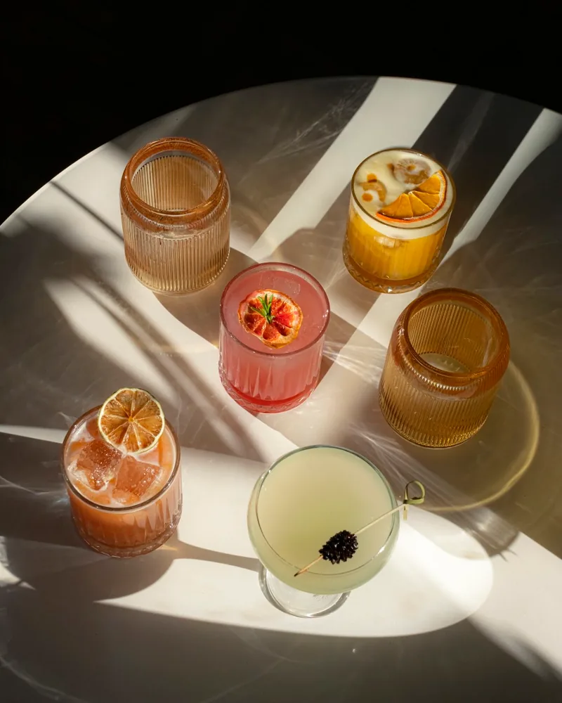 Assortment of cocktails on a sunlit table at Unfound Door