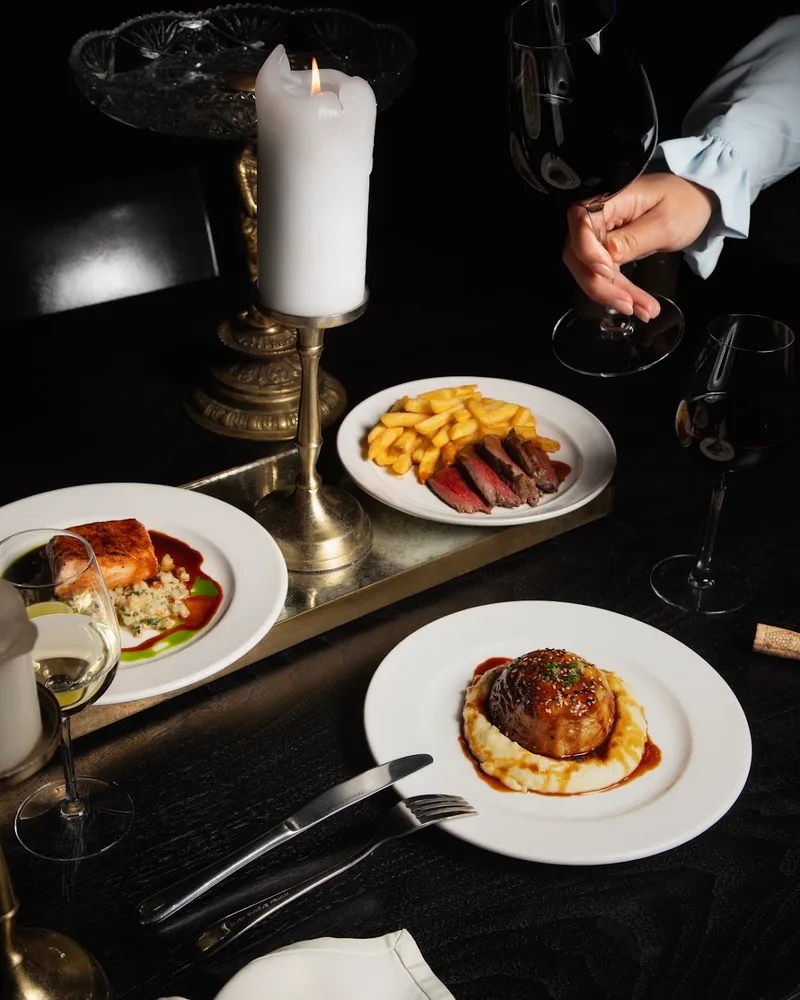 Dinner spread with steak frites, salmon, and meatball over mash at Unfound Door Restaurant