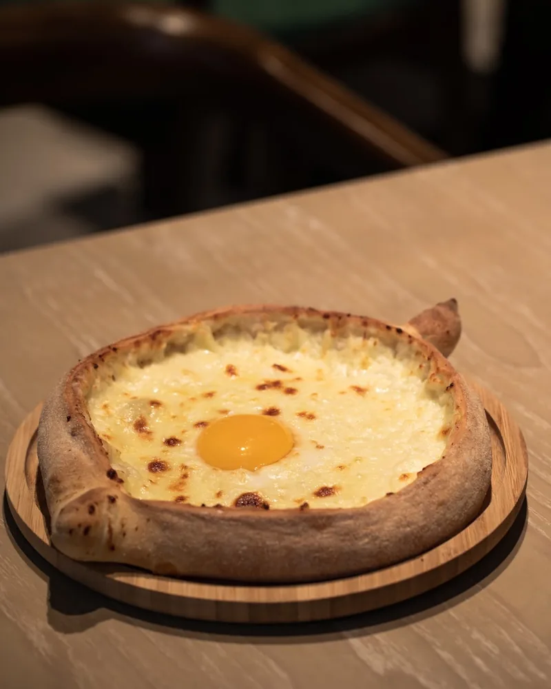 Adjarian khachapuri on a wooden board at Vakhtanguri