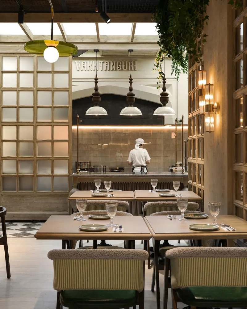Dining room with wooden lattice partitions and tables at Vakhtanguri
