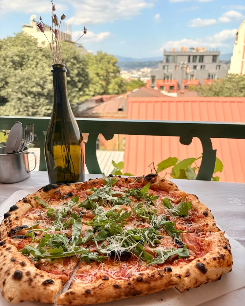 Pizza topped with rocket and shaved cheese at Viola