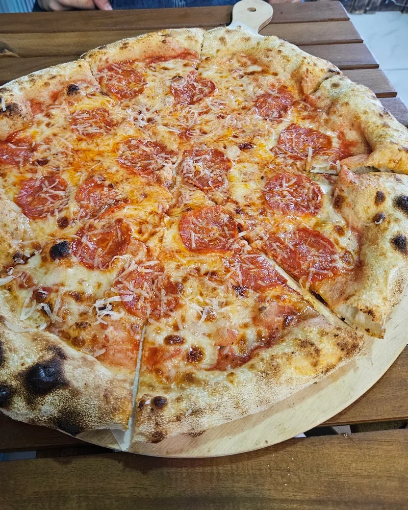Pepperoni pizza on wooden peel at Viola