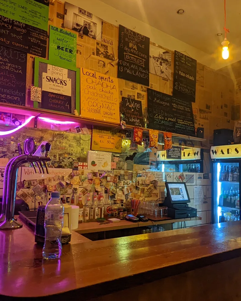 Wooden bar counter and tap with menu boards at Warszawa