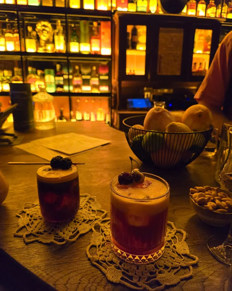 Two cocktails with foam and berry garnishes at Whisky Library