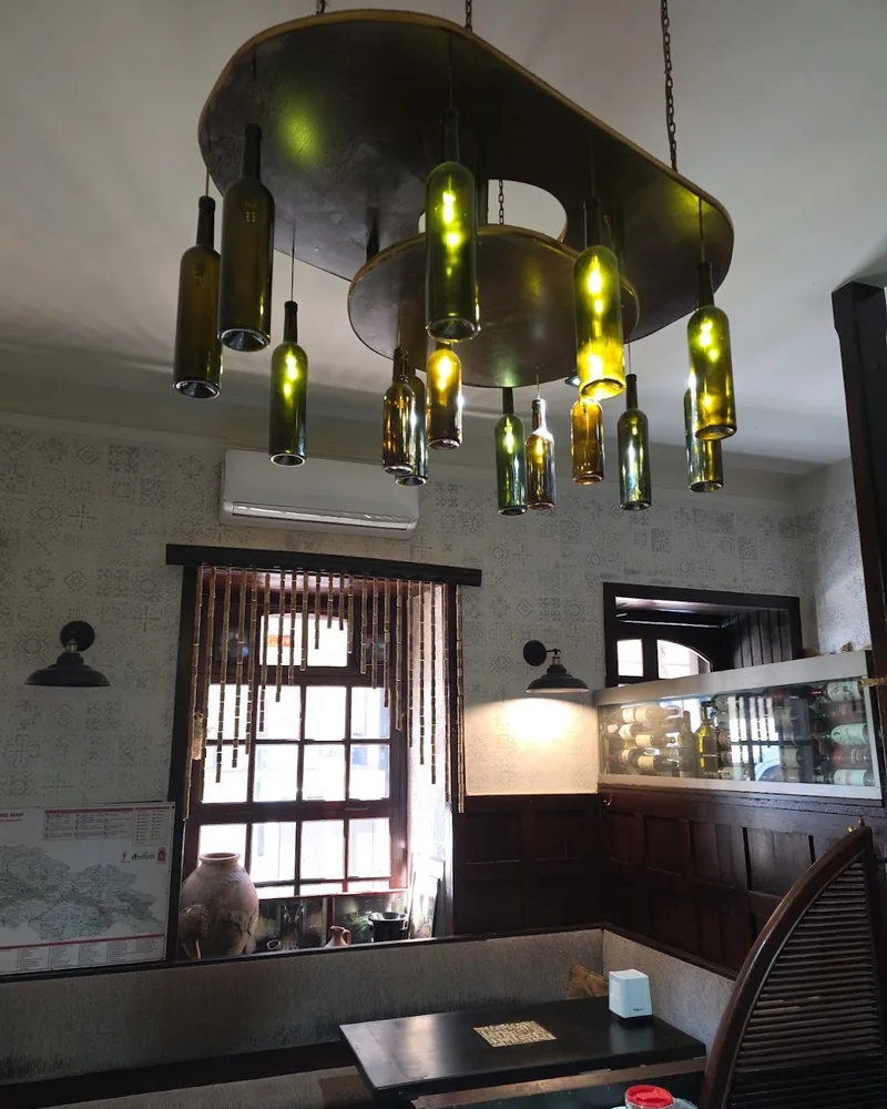 Wine bottle chandelier over booth seating at Sancho Wine Bar