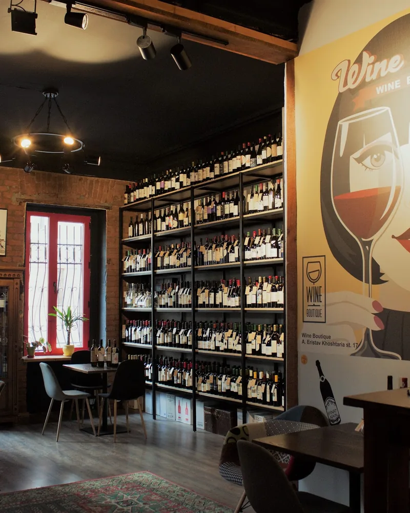 Wine tasting room with bottle shelves and mural at Wine Boutique