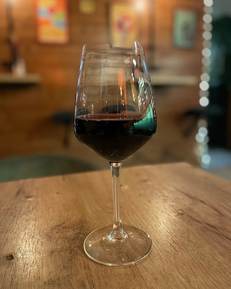 Glass of red wine on a wooden table at Wine Not?