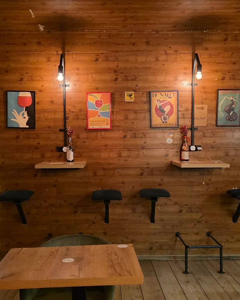 Wood-panelled seating area with wine shop alcove at Wine Not?