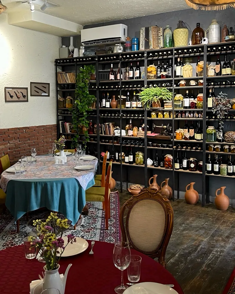 Dining room with wine shelves and set tables at Wine Point