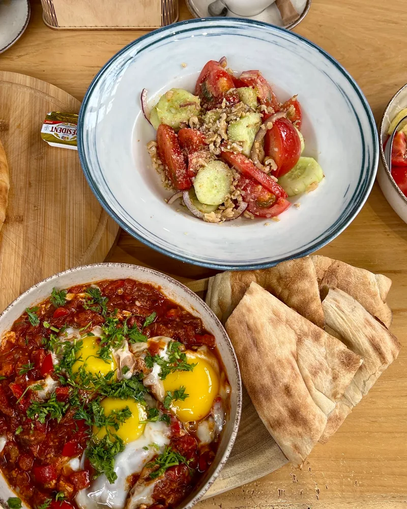 Breakfast spread with shakshuka, khachapuri, and salad at WineCode