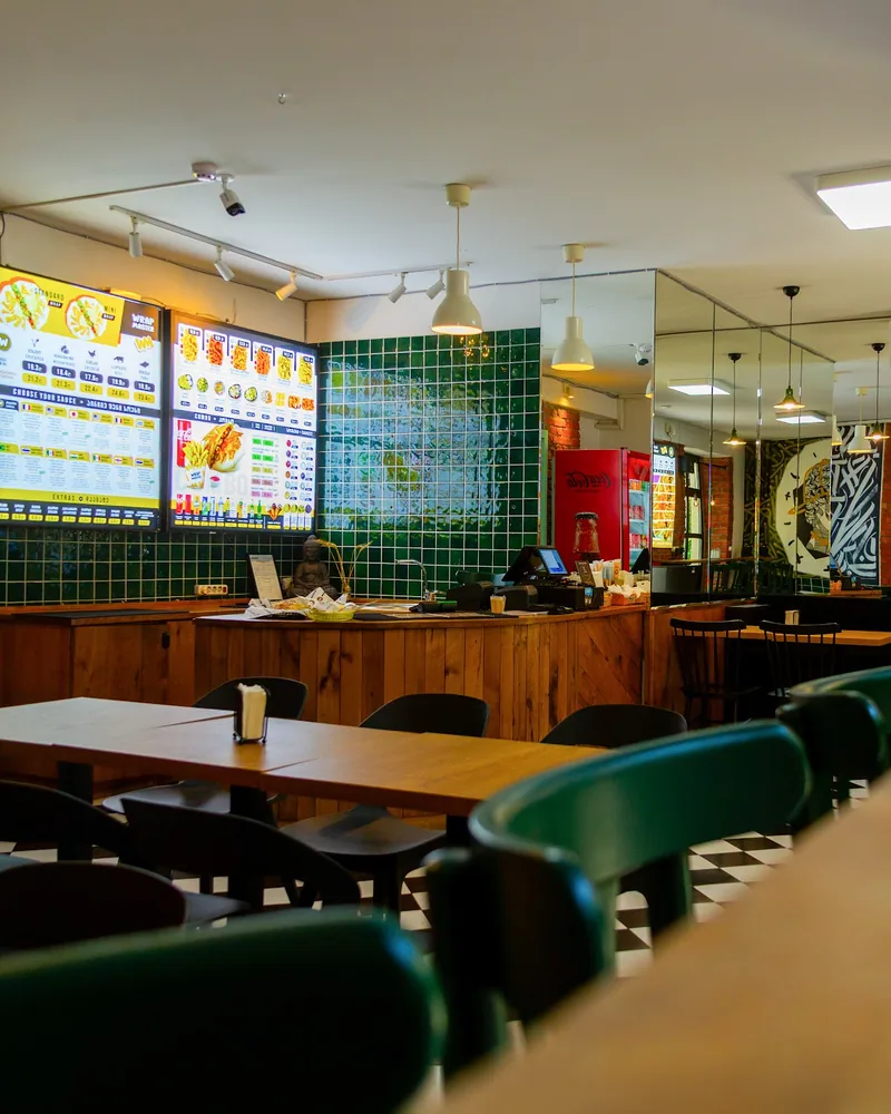 Counter and dining tables with graphic mural and mirrors at Wrap Master